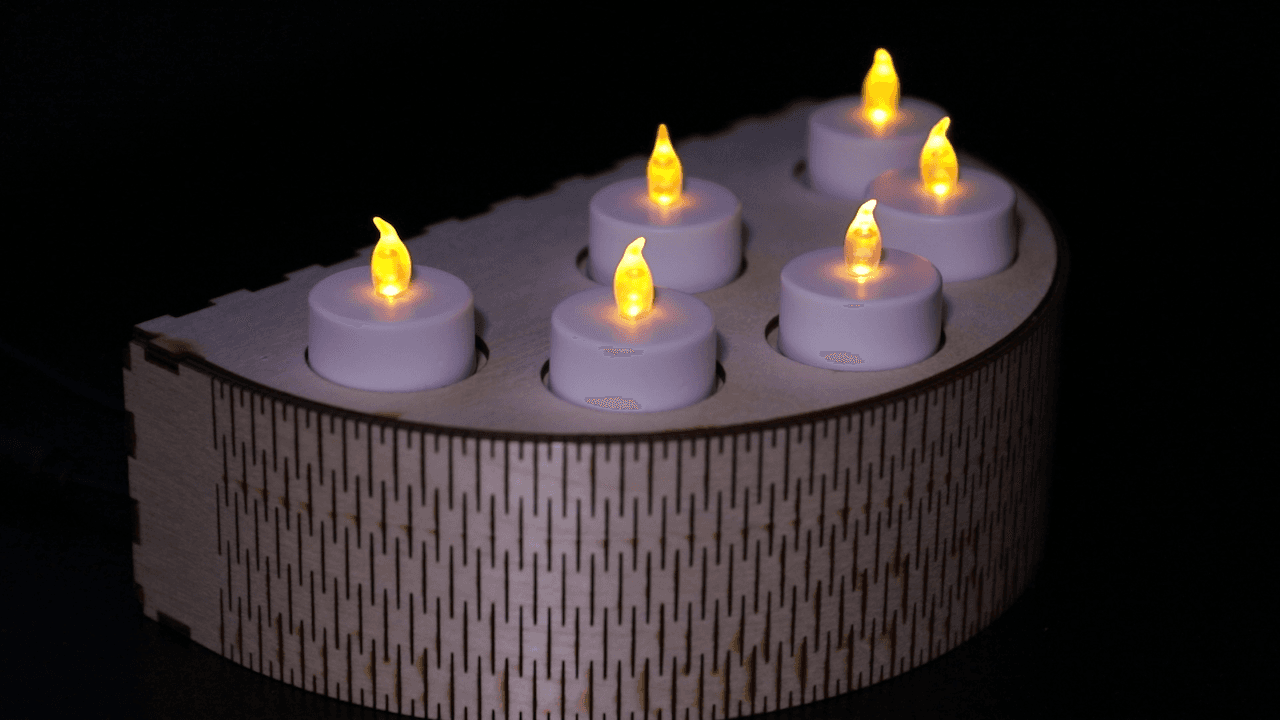 A wooden candle holder with 6 fake candles sitting on it. The candle holder is a half-circle, where the face of the circle is the top of the holder. The candles are lit.
